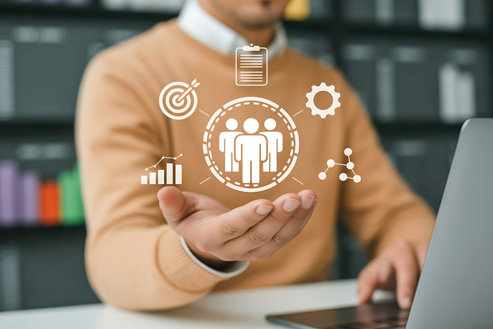 Pessoa utilizando computador com ícones digitais de gestão e equipe, representando organização, planejamento e gestão de benefícios corporativos.