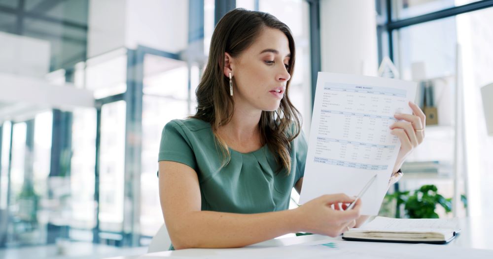 O profissional analisa documentos financeiros em escritório, ilustrando processos administrativos relacionados ao trabalho intermitente.